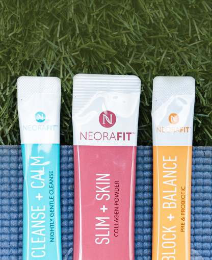 NeoraFit 胶原蛋白粉, NeoraFit 益生粉与NeoraFit 净体粉小包放在草地上的瑜伽垫上 